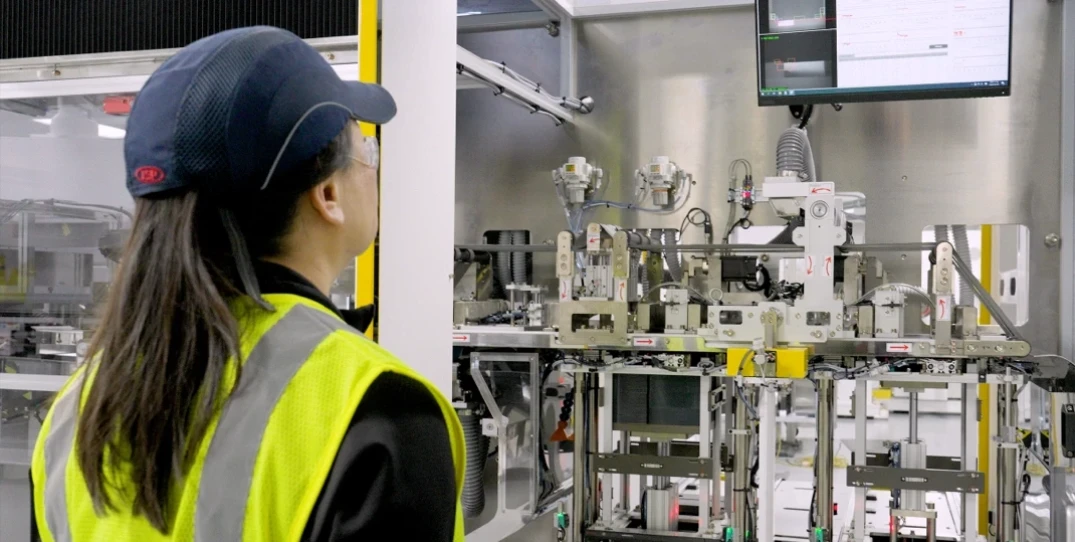 Woman in factory looking at technology